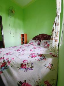 a bedroom with a large bed with flowers on it at Homestay Barokah in Magelang