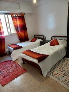 a bedroom with two beds and a window at STAR APPARTEMENT GAUTHIER in Casablanca