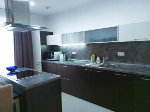 a kitchen with black cabinets and a sink and a counter at A&M Apartment Donovaly in Donovaly