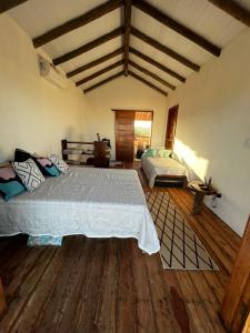 1 dormitorio con 1 cama grande y suelo de madera en Chalé Lampião Caraiva, en Caraíva