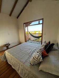 um quarto com uma cama grande e uma janela grande em Chalé Lampião Caraiva em Caraíva