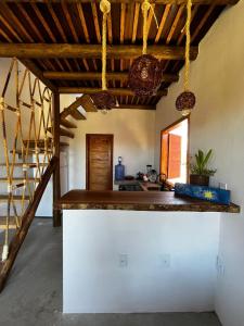 uma cozinha com tectos em madeira e uma bancada em Chalé Lampião Caraiva em Caraíva