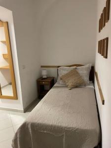 una piccola camera da letto con letto e specchio di Matteo House nel cuore di Sorrento a Sorrento
