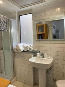 bagno con lavandino, specchio e doccia di Matteo House nel cuore di Sorrento a Sorrento