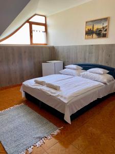 1 dormitorio con 2 camas y alfombra en Muskátli Panzió és Étterem, en Újhartyán