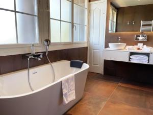 a bathroom with a bath tub and a sink at Le Grand Hôtel Le Touquet-Paris-Plage in Le Touquet-Paris-Plage