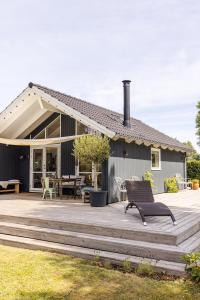 a house with a wooden deck with a patio at Modern and cozy cabin near Copenhagen city and airport in Dragør