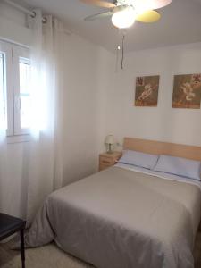 a bedroom with a bed and a ceiling fan at Verdemar Apartamento Bajo in Peñíscola