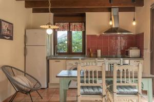 cocina con mesa, sillas y nevera en Casa de aldea el Toral, en Rales