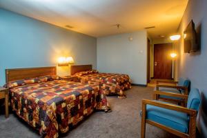 a hotel room with two beds and a chair at Lafayette Inn in Moundsville +38 photos