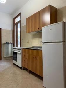 ラーカレにあるCasa Della Nonnaのキッチン(白い冷蔵庫、木製キャビネット付)