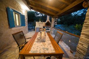 a wooden table and chairs on a patio at Holiday Home Casa Oliva II in Nerezine