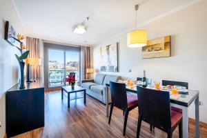 salon ze stołem i kanapą w obiekcie 797 HOLIDAY RENTALS - ARCOSUR1- Moderno apartamento con terraza y vistas w mieście Benalmádena