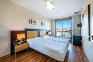 sypialnia z dużym łóżkiem i dużym oknem w obiekcie 797 HOLIDAY RENTALS - ARCOSUR1- Moderno apartamento con terraza y vistas w mieście Benalmádena