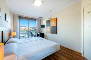 sypialnia z dużym łóżkiem i dużym oknem w obiekcie 797 HOLIDAY RENTALS - ARCOSUR1- Moderno apartamento con terraza y vistas w mieście Benalmádena +17 zdjęć