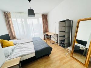 1 dormitorio con 1 cama grande y espejo en Zentrales großzügiges Apartment mit Dachterrasse!, en Bochum