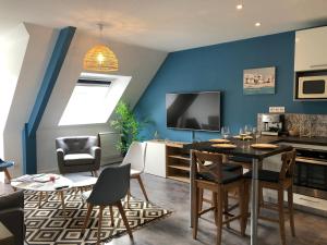 a living room with blue walls and a table and chairs at Le Saint-Patern - T3 centre-ville et garage sécurisé in Vannes +5 photos