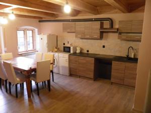 een keuken met een houten tafel en een eetkamer bij Apartament Rynek 30 in Osieczna