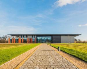 a building with a brick road in front of a field at Centrally located in city of Lincoln Idas Place - two bedrooms each with a kingsize bed in Lincolnshire