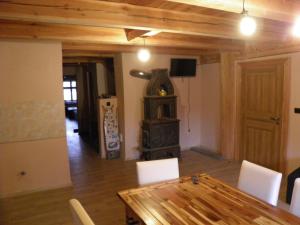 een eetkamer met een houten tafel en een houtkachel bij Apartament Rynek 30 in Osieczna