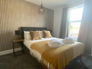 um quarto com uma cama com toalhas em Centrally located in city of Lincoln Idas Place - two bedrooms each with a kingsize bed em Lincolnshire