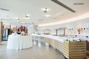 duża kuchnia z białymi blatami i stołem w obiekcie RMH Lazure Luxury Apartments w mieście Lopud