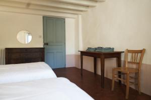 1 dormitorio con 2 camas, mesa y silla en La Cour du Marronnier, en Pont-de-Barret