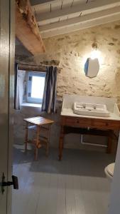 Habitación con baño con lavabo y mesa. en La Cour du Marronnier, en Pont-de-Barret