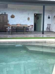 a swimming pool with a table and chairs next to a house at Aura Rural, Montes de Toledo in San Pablo de los Montes