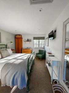 a bedroom with a bed and a desk and a television at The Crown Inn in Lanlivery