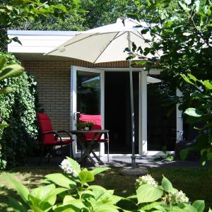 a patio with an umbrella and a table and chairs at B&B de Linde in Hoogeveen
