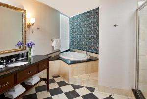 a bathroom with a tub and a sink at The Battle House Renaissance Mobile Hotel & Spa in Mobile