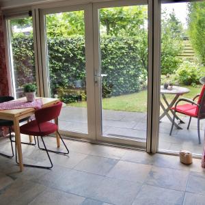 a patio with sliding glass doors and a table and chairs at B&B de Linde in Hoogeveen