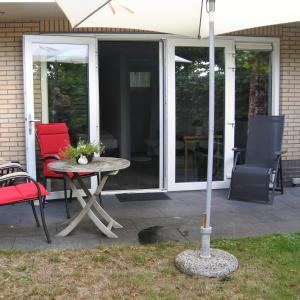 a patio with a table and chairs and an umbrella at B&B de Linde in Hoogeveen