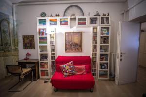 ローマにあるIl Leoncinoの本棚付きの部屋の赤い椅子