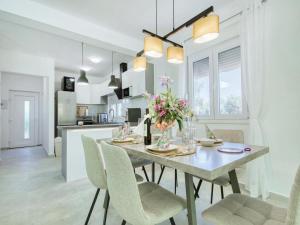 cocina y comedor con mesa y sillas en Luxury Villa Gaby with Heated Pool en Božava