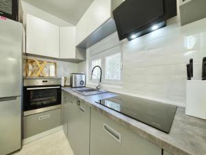 a kitchen with white cabinets and a stainless steel refrigerator at Luxury Villa Gaby with Heated Pool in Božava
