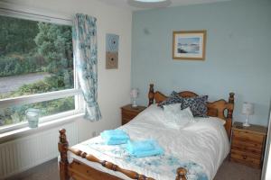 een slaapkamer met een bed met blauwe handdoeken bij Dunmara: Self Catering Cottage on the Isle of Skye in Broadford