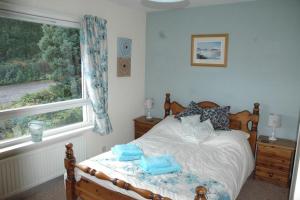 a bedroom with a bed with blue towels on it at Dunmara: Self Catering Cottage on the Isle of Skye in Broadford