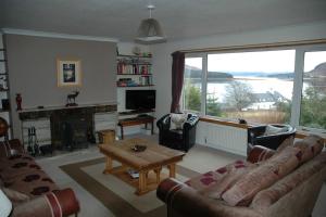 Dunmara: Self Catering Cottage on the Isle of Skye في برادفورد: غرفة معيشة مع أريكة وطاولة
