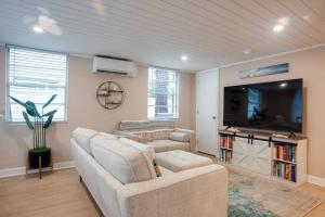 uma sala de estar com um sofá e uma televisão de ecrã plano em Renovated Cottage: 4th row from the Beach! em Hilton Head Island