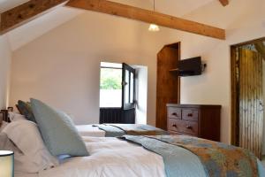 een slaapkamer met een groot bed en een raam bij Ponycob hot tub 2 bed ensuite in Llwyn-Dafydd