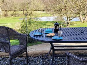 een blauwe tafel met borden met voedsel erop bij Ponycob hot tub 2 bed ensuite in Llwyn-Dafydd