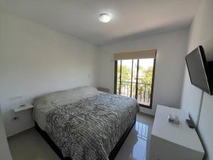 Habitación pequeña con cama y ventana en Hermoso y luminoso departamento en Godoy Cruz en Godoy Cruz