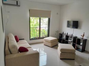sala de estar con 2 sofás y TV en Hermoso y luminoso departamento en Godoy Cruz en Godoy Cruz