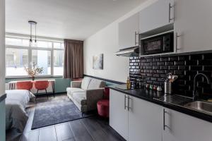 een keuken met een wastafel en een woonkamer bij Hey - Aparthotel Brussels in Brussel