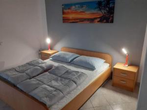 a bedroom with a bed with two lamps on it at Apartments Felicce in Rab