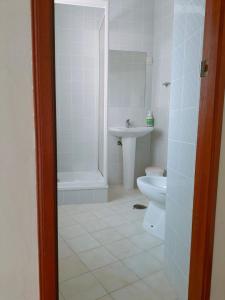 a white bathroom with a sink and a toilet at Anoitecer Itinerante AL - antiga residencial o garfo in Ponte de Lima