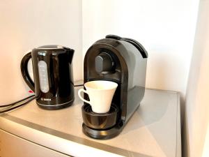una cafetera y una taza de café en una barra en Apartament Aviator en Mielec