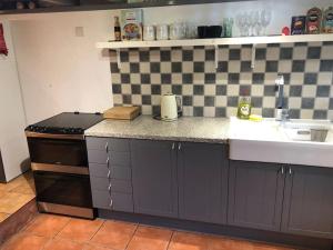 a kitchen with a sink and a stove at Coastal Village Cottage in Talacre